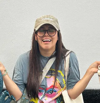 Fundadora de What the Cap sonriendo con gorra bordada 'mamá'